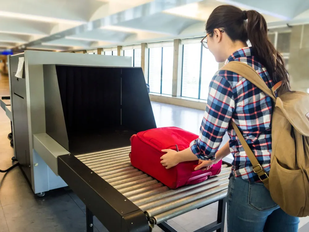 woman putting bag on security xray tsa screening
